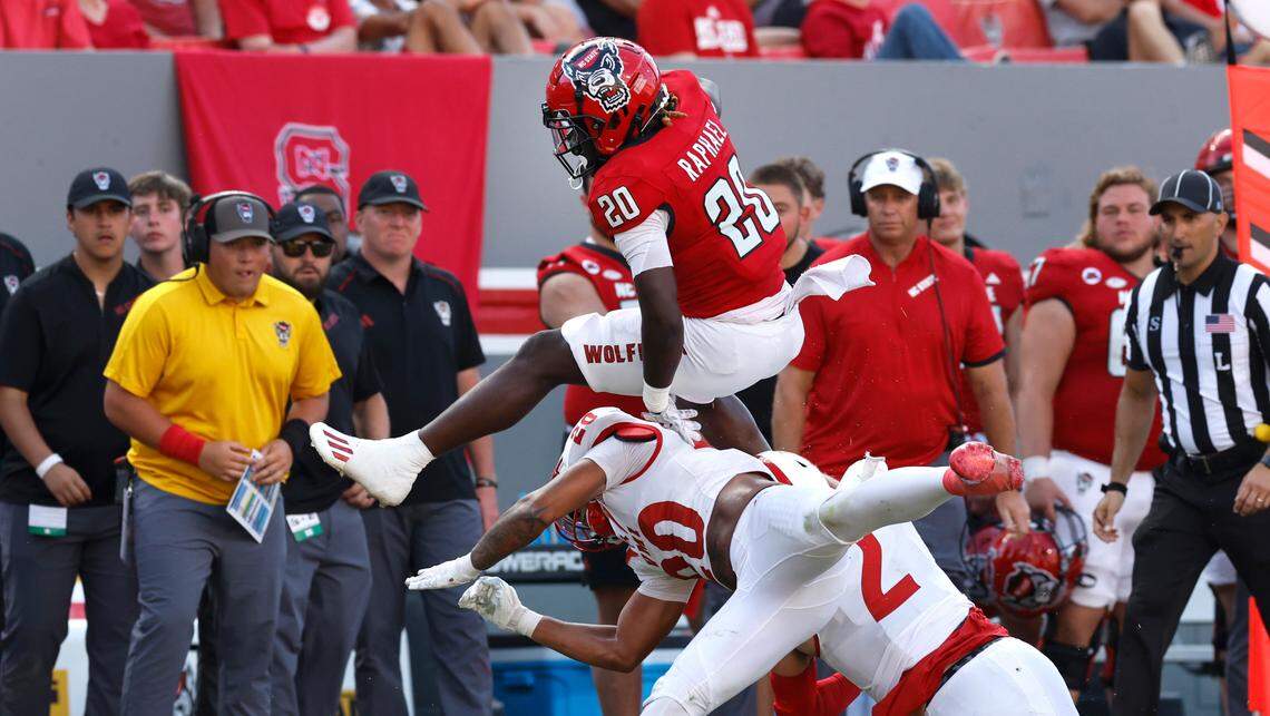 N.C. State running back Kendrick Raphael (20) hurdles over Virginia Military Institute defensive back Shamus Jones (20) during the second half of the Wolfpack’s 45-7 victory over VMI at Carter-Finley Stadium in Raleigh, N.C., Saturday, Sept. 16, 2023.