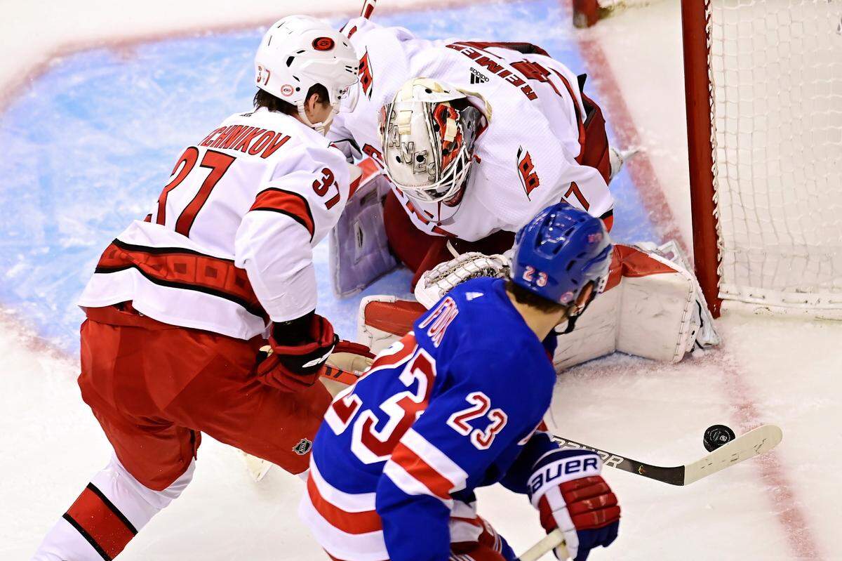 Carolina Hurricanes’ goaltender James Reimer (47) looks for the puck as Hurricanes’ Andrei Svechnikov (37) and New York Rangers’ Adam Fox (23) chase during second period NHL Eastern Conference Stanley Cup playoff action in Toronto on Tuesday, Aug. 4, 2020. (Frank Gunn/The Canadian Press via AP)