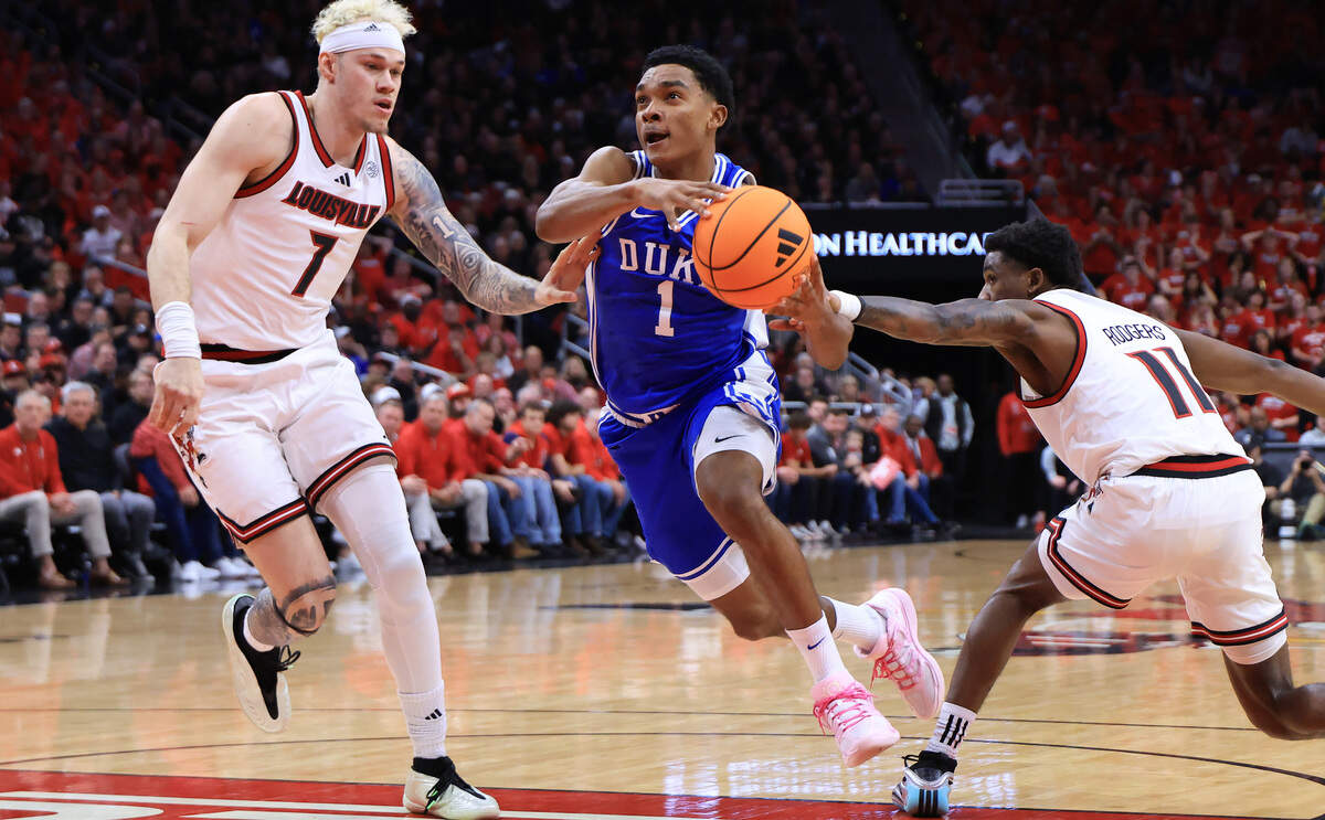 Caleb Foster of the Duke Blue Devils goes to the basket against as  Kasean Pryor and Kobe Rodgers of the Louisville Cardinals defend during the first half at KFC YUM! Center on January 06, 2026 in Louisville, Kentucky.