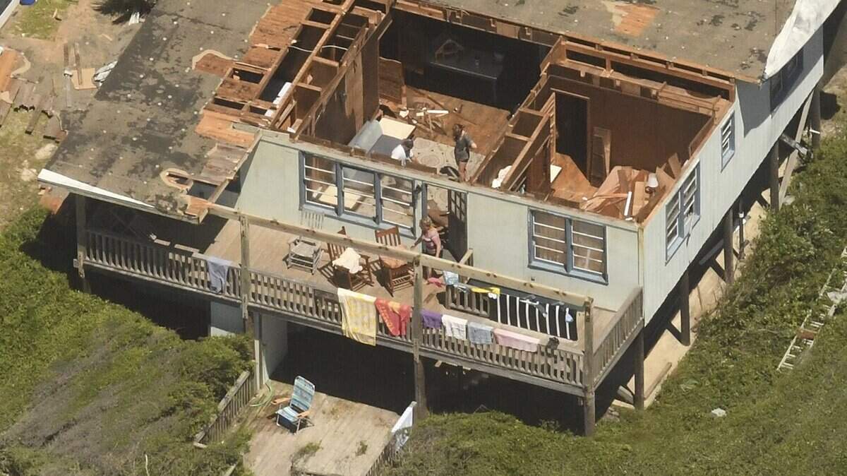 People look over their home in Oak Island, N.C. after Hurricane Isaisas came ashore Tuesday night Aug. 4, 2020 in Brunswick County as a category 1 hurricane. The storm cause damage along all of the southern beaches like Ocean Isle Beach, Holden Beach, Oak Island and Southport.