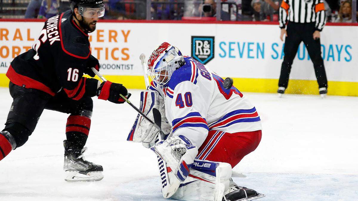 Carolina Hurricanes’ Vincent Trocheck (16) has his shot go over the shoulder of New York Rangers goaltender Alexandar Georgiev (40) during the second period of an NHL hockey game in Raleigh, N.C., Sunday, March 20, 2022. (AP Photo/Karl B DeBlaker)