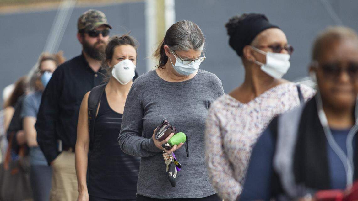 Customer keep a distance of 6 feet apart while waiting in line outside Trader Joe’s in Raleigh Tuesday, April 7, 2020. The store is limiting 40 customers in the store at once as customers are asked to adhere to social distancing standards while waiting in lines.