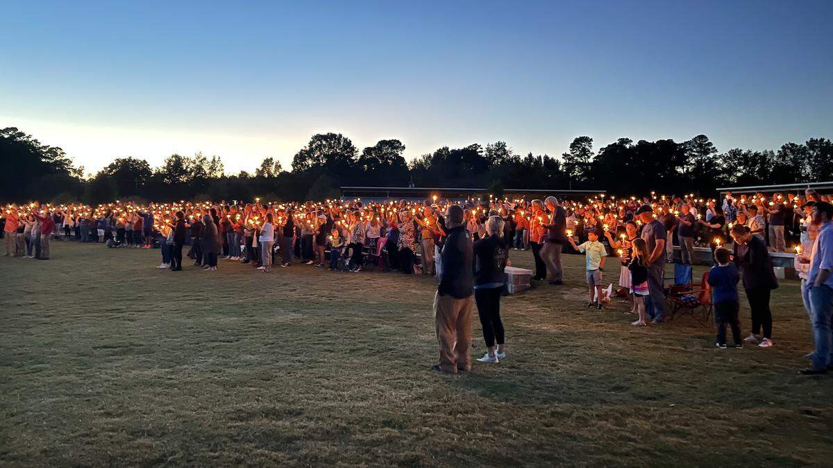 Hundreds of people hold up candles during a vigil for Knightdale police officer Ryan Hayworth at Knightdale Station Park on Wednesday, Oct. 20, 2021.