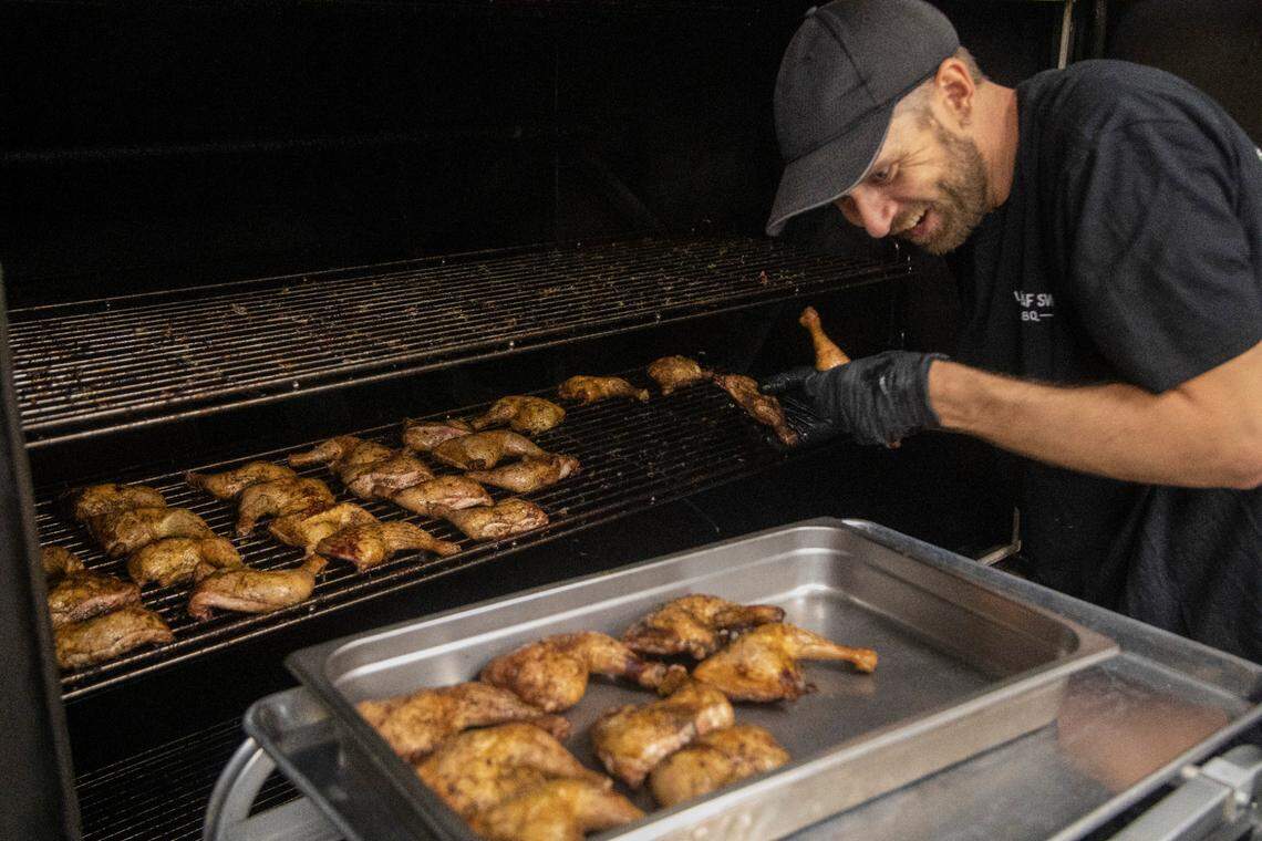 Chicken comes out of the smoker during the opening of Longleaf Swine in Raleigh Friday, Nov. 4, 2022.