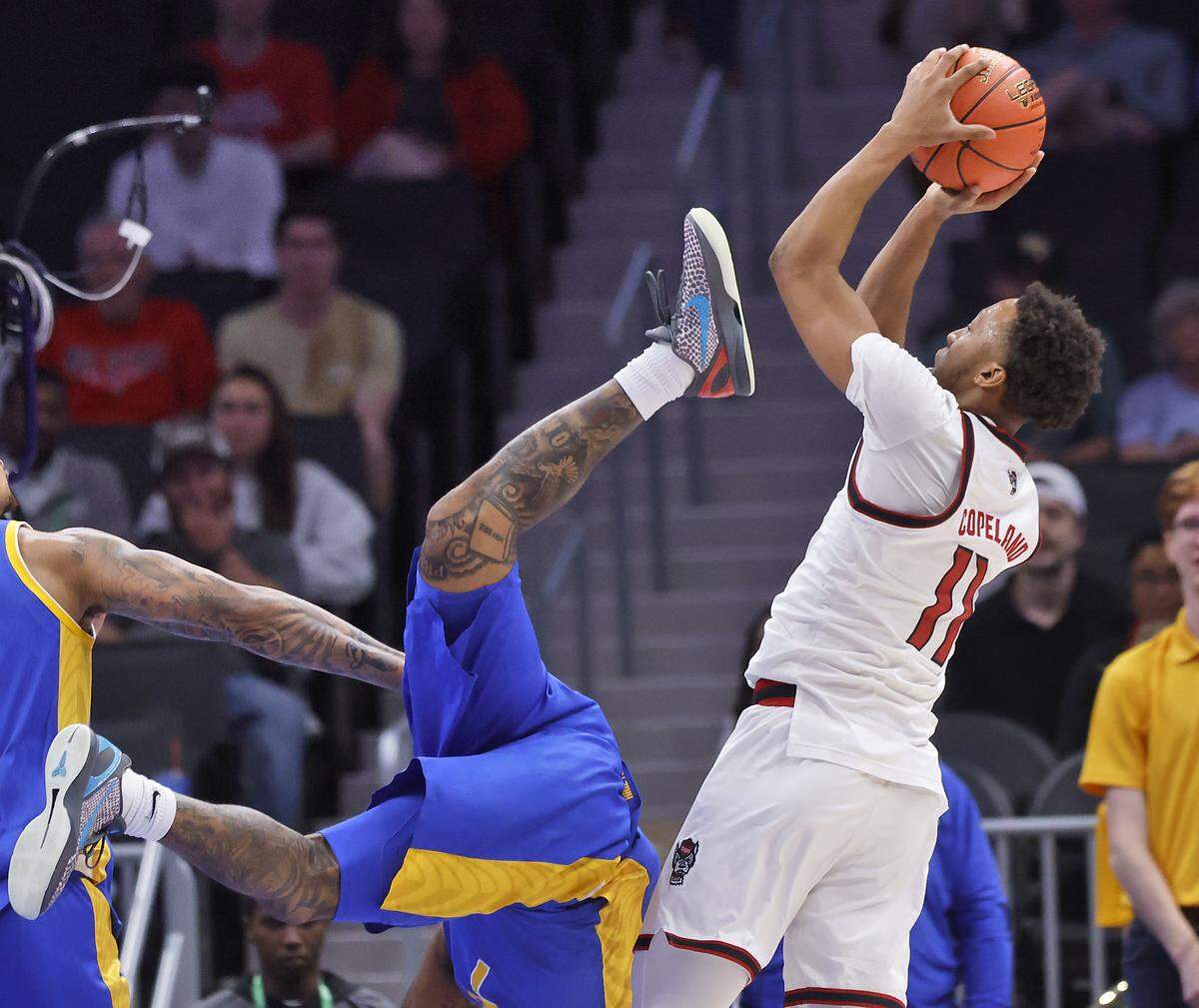 N.C. State's Quadir Copeland looks to shoot over Pitt’s Damarco Minor during the first half of the Wolfpack’s second-round ACC Tournament game on Wednesday, March 11, 2026, at the Spectrum Center in Charlotte, N.C. 