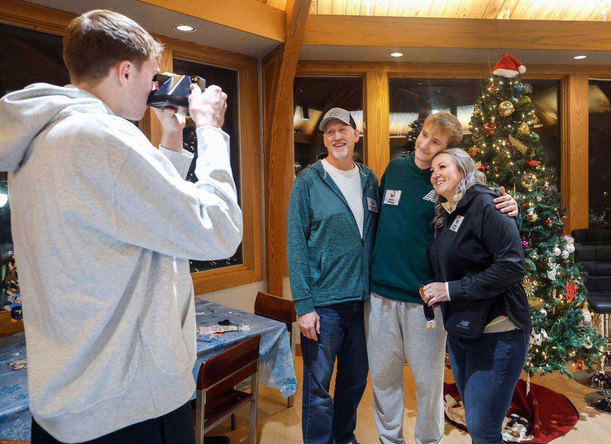 Cooper Flagg takes a polaroid photo of his dad Ralph, brother Ace and mom Kelly after a holiday gathering at the Ronald McDonald House Charities of the Triangle in Durham, N.C., Thursday, Dec. 12, 2024.