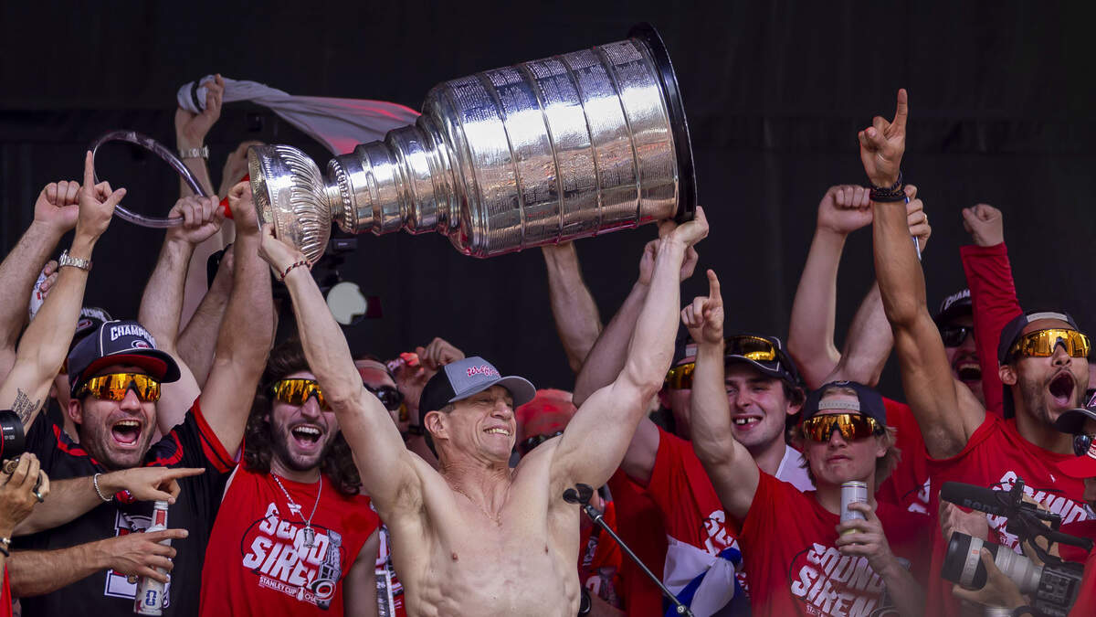 A shirtless Carolina Hurricanes head coach Rod Brind’Amour, hoists the Stanley Cup during the celebration rally on the City Plaza on Saturday, June 20, 2026 in Raleigh, NC.