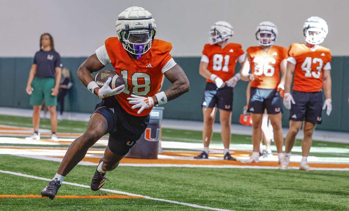 Miami Hurricanes wide receiver Chance Robinson (18) runs through practice drills with teammates at the Carol Soffer Indoor Practice Facility in Coral Gables, Florida, on Thursday, July 31, 2025. 