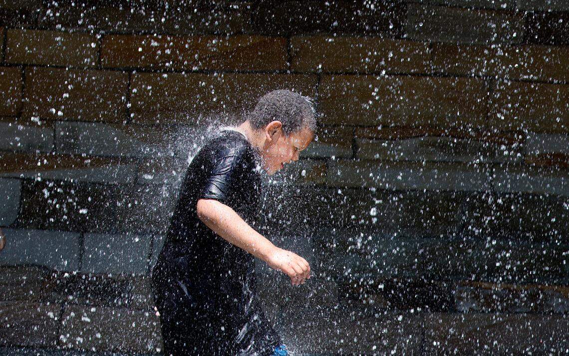 Dylan Warren, 8, of Knightdale enjoys the waterfall at Gipson Play Plaza at Dix Park during a preview day Saturday, May 24, 2025.