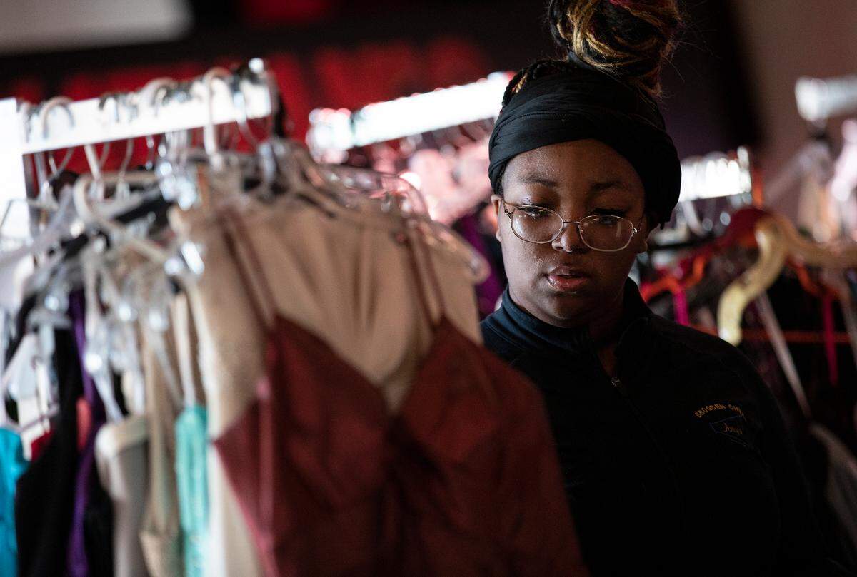 Aniyah Marshburn, an eighth grade student at Brogden Middle School in Goldsboro, browses clothing racks during a prom dress drive held by the Hall Foundation on Wednesday, April 20, 2022, at Jonathan’s Sports Lounge & Grill in Raleigh, N.C.