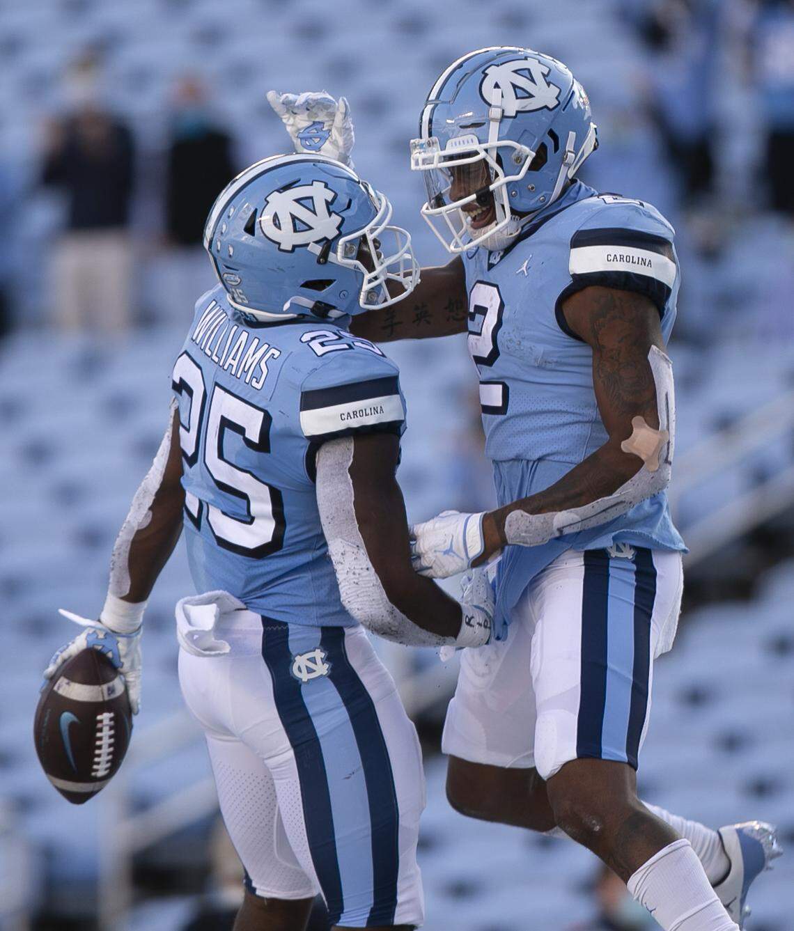 North Carolina’s Javonte Williams (25) celebrates with teammate Daymi Brown (2) after scoring on a 15-yard carry late in the fourth quarter to secure the Tar Heels’ 59-53 victory over Wake Forest at Kenan Stadium on Saturday, November 14, 2020 in Chapel Hill, N.C.