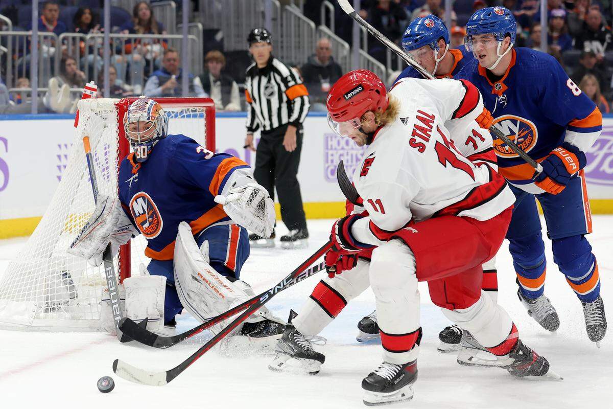 Nov 4, 2023; Elmont, New York, USA; Carolina Hurricanes center Jordan Staal (11) fights for the puck against New York Islanders goaltender Ilya Sorokin (30) and defensemen Scott Mayfield (24) and Noah Dobson (8) during the third period at UBS Arena. Mandatory Credit: Brad Penner-USA TODAY Sports
