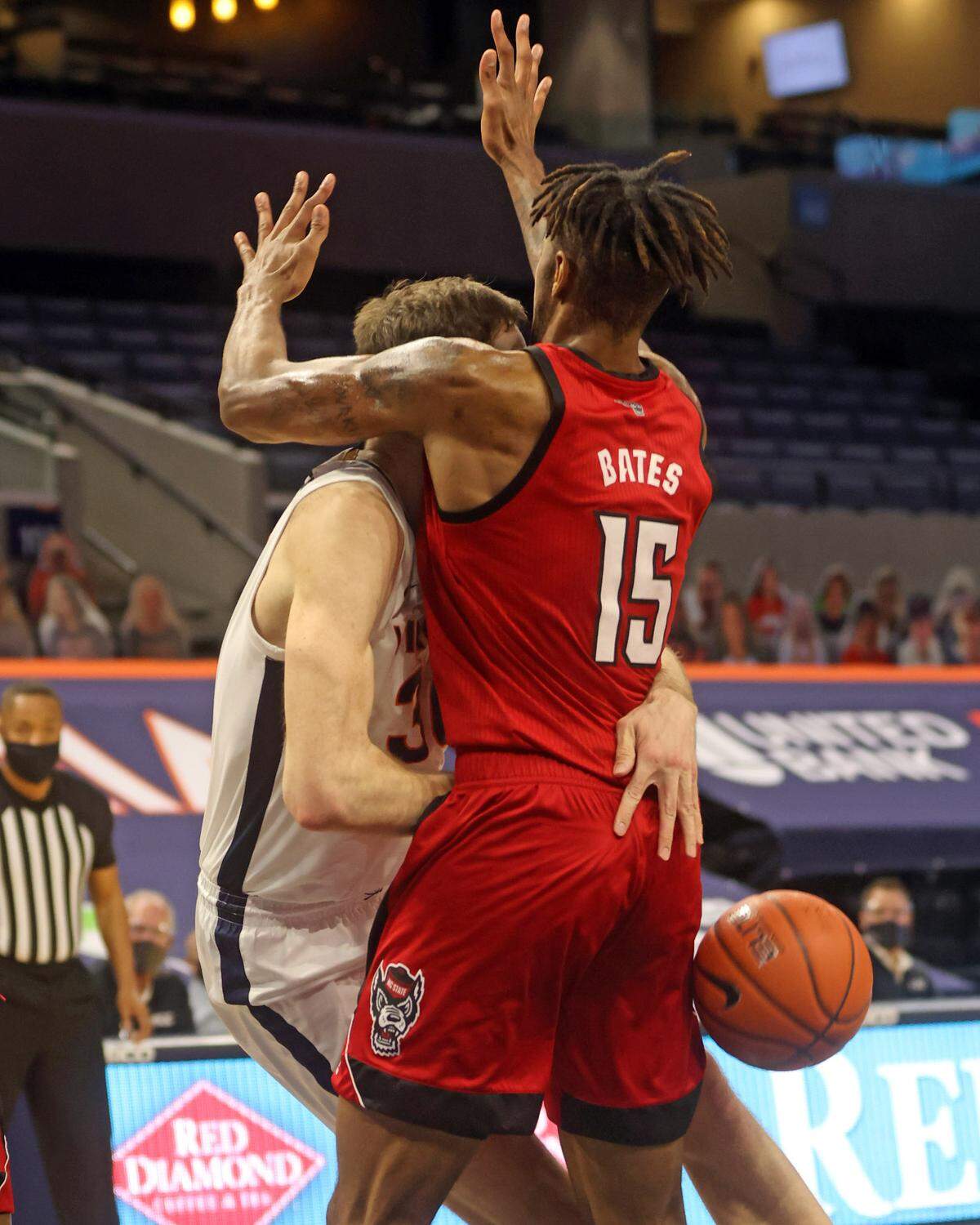 Virginia forward Jay Huff (30) is fouled by North Carolina State forward Manny Bates (15) during the game Wednesday.