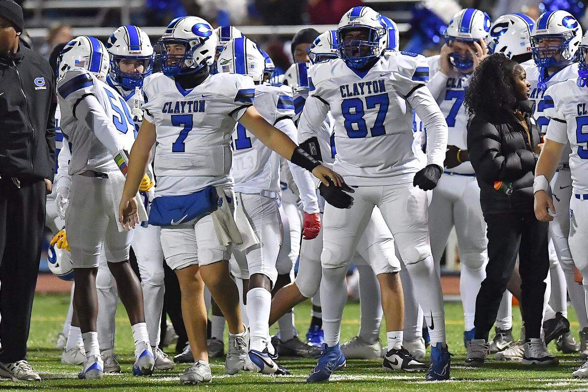 Clayton's Carson Jones (7) and Cedric Simmons (87) react to Cardinal Gibbons missing the field goal attempt during the first half. The Clayton Comets and the Cardinal Gibbons Crusaders met in the East Regional Final of the NCHSAA 7A Football Championship in Clayton, N.C. on December 4, 2025.