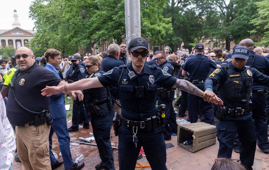Interim Chancellor Lee Roberts and police officers work to rehang an American flag after it was brought down by demonstrators and replaced with a Palestinian flag Tuesday, April 30, 2024 at UNC-Chapel Hill. About 1000 pro-Palestinian demonstrators rallied after a “Gaza solidarity encampment” was removed by police early Tuesday morning.
