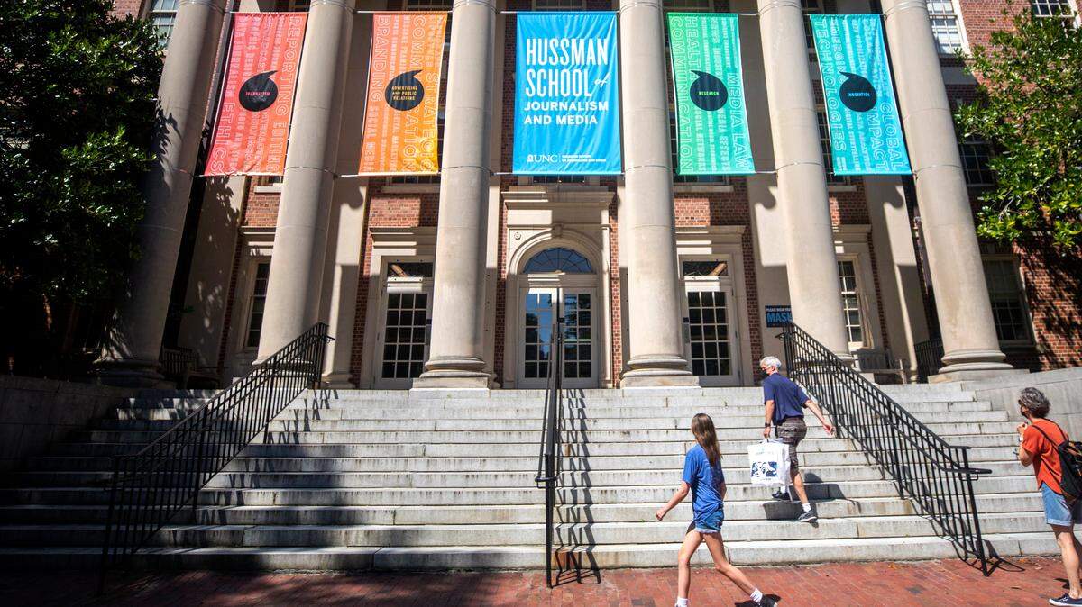 Visitors of UNC-Chapel Hill walk up the steps of Carroll Hall, the building housing the Hussman School of Journalism and Media, in Chapel Hill, N.C. on Wednesday, July 14, 2021.