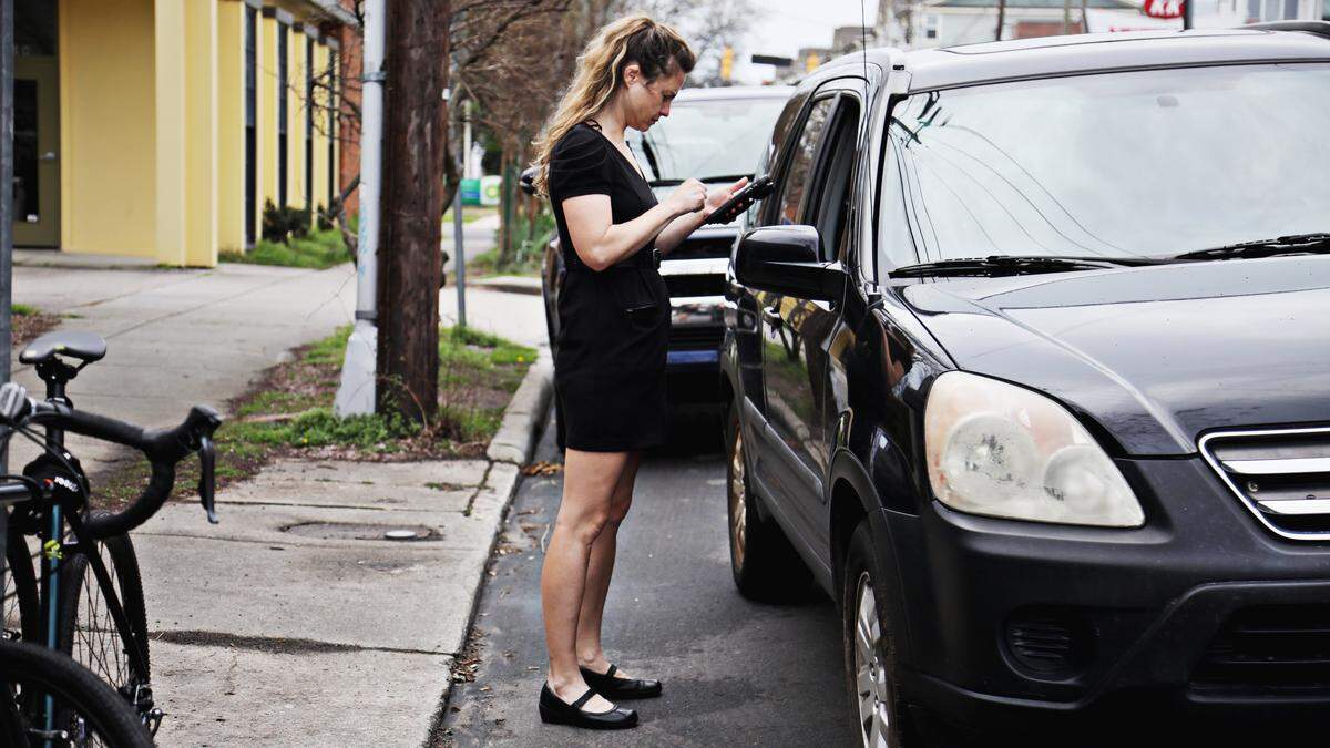 Oakwood Pizza Box employee Katie Stephens runs a credit card curbside for a customer on Friday, March 12, 2020. The downtown Raleigh restaurant has set up a “pizza valet” so customers can drive up and pay from their car and have their pizza handed to them.