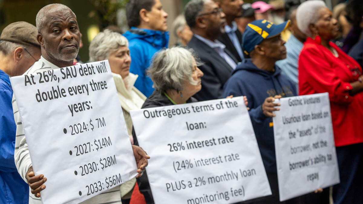 Dozens of clergy members, civil rights activists, and St. Augustine’s University alumni gather at City Plaza in Raleigh on Wednesday, Nov. 20, 2024, to rally for more favorable terms on a multimillion-dollar loan for the struggling historically Black university.