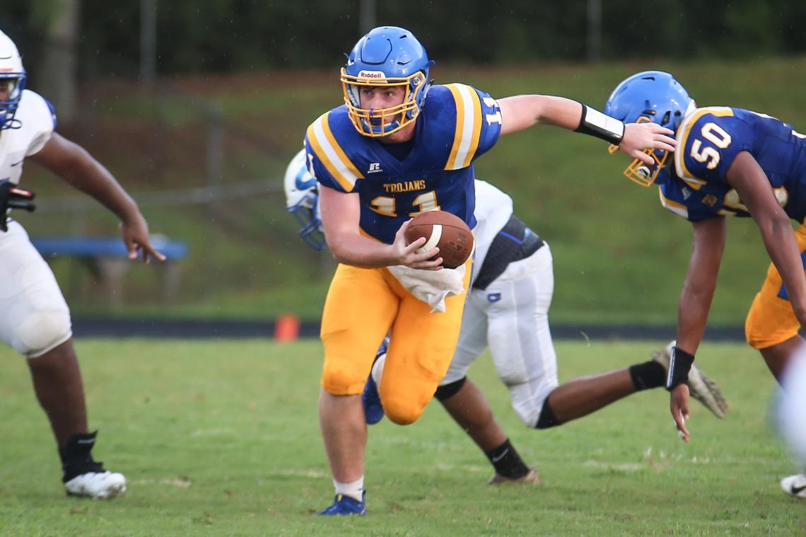 Garner quarterback Nolan Mclean (11) escapes pressure in the pocket. The Clayton Comets played football at the Garner Trojans on Friday, August 17, 2018.
