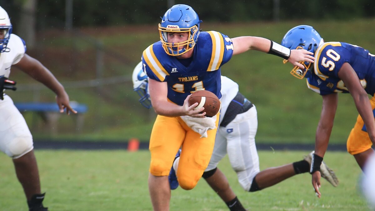 Garner quarterback Nolan Mclean (11) escapes pressure in the pocket. The Clayton Comets played football at the Garner Trojans on Friday, August 17, 2018.