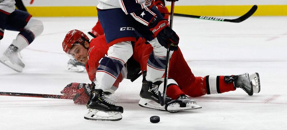 Carolina right wing Jesper Fast (71) kicks the puck away from Columbus right wing Justin Danforth (17) during the first period of the Carolina Hurricanes game against the Columbus Blue Jackets at PNC Arena in Raleigh, N.C., Wednesday, Oct. 12, 2022.
