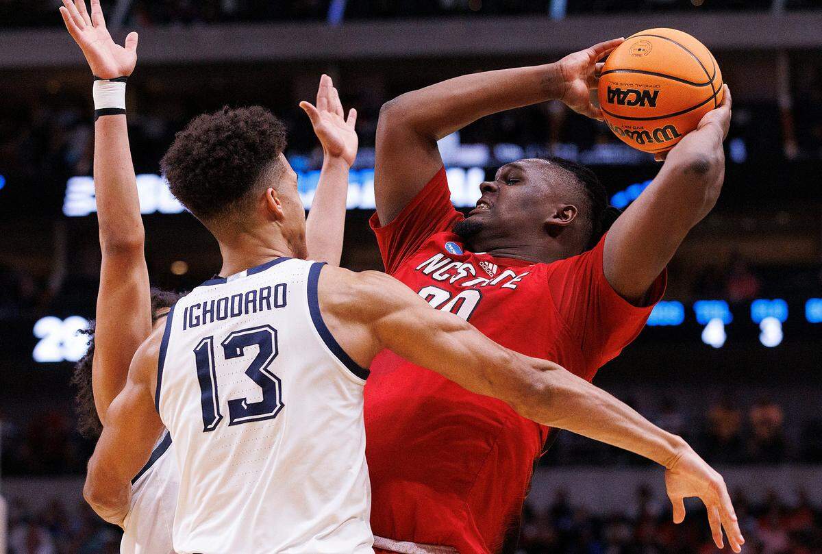 N.C. State’s DJ Burns Jr. looks to pass around Marquette’s Oso Ighodaro during the first half of the Wolfpack’s NCAA Tournament Sweet 16 matchup on Friday, March 29, 2024, at American Airlines Center in Dallas, Texas.