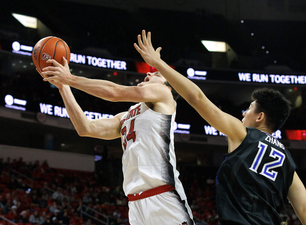 N.C. State’s Ben Middlebrooks drives to the basket past Saint Louis’ Bruce Zhang during the second half of the Wolfpack’s 82-70 win on Wednesday, Dec. 20, 2023, at PNC Arena in Raleigh, N.C.