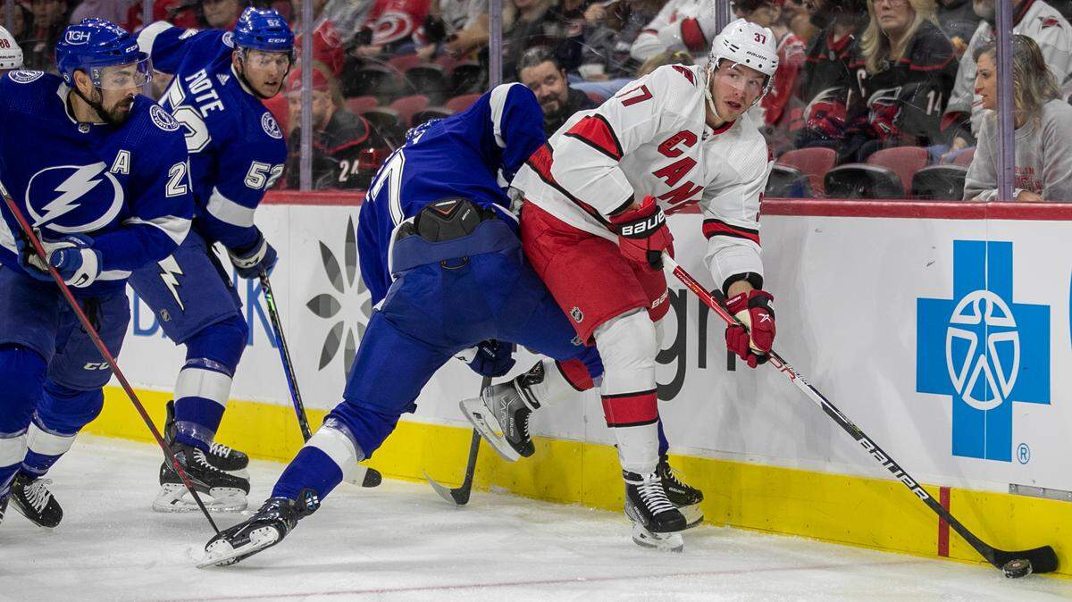 Carolina Hurricanes’ Andrei Svechnikov (37) controls the puck along the board against Tampa Bay’s Haydn Fleury (7) during the first period of an NHL preseason game on Tuesday, September 27, 2022 at PNC Arena in Raleigh, N.C.