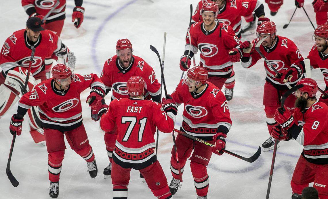 The Carolina Hurricanes swarm to Jesper Fast (71) during their post-game celebration after Fast scored the game winning goal in overtime to secure a 3-2 victory over the New Jersey Devils, clinching their second round Stanley Cup series on Thursday, May 11, 2023 at PNC Arena in Raleigh, N.C.