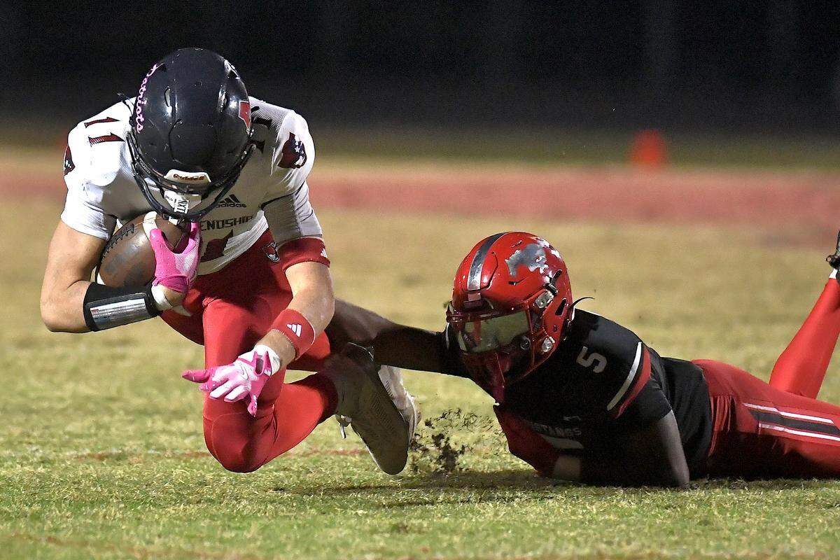 Apex Friendship’s David Lozada (11) dives for yardage against Middle Creek corner back Christian Prince (5) during the first half. The Middle Creek Mustangs and the Apex Friendship Patriots met in a football game in Cary, N.C. on October 25, 2024.