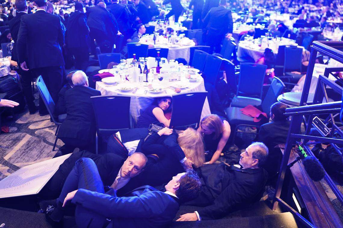 Guests take cover after a unknown safety event took place as President Donald Trump was to speak to attendees of the annual White House Correspondents Association Dinner April 25, 2026 in Washington, DC. According to reports, President Donald Trump, along with other government officials, were evacuated from the Washington Hilton after what sounded like gun fire. 