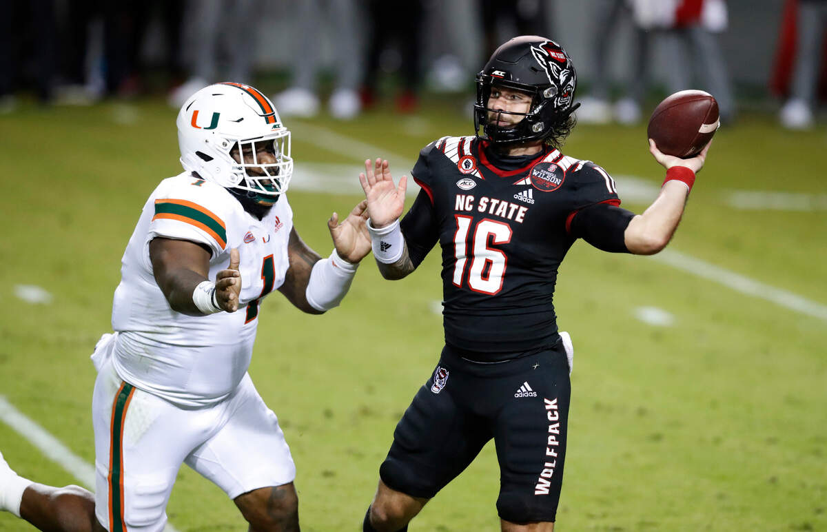 N.C. State quarterback Bailey Hockman (16) prepares to pass while pressured by Miami defensive lineman Nesta Jade Silvera (1) during the first half of N.C. State’s game against Miami at Carter-Finley Stadium in Raleigh, N.C., Friday, Nov. 6, 2020.