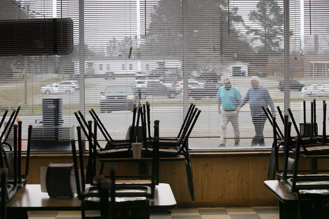 Mike Williams, left, and James Warrick walk to the Nashville Diner on Thursday, March 19 to pick up their take-out orders after their dining room was closed due the spread of the COVID-19 virus. The popular restaurant is usually filled with customers where many meet and socialize in the rural Nash County town.
