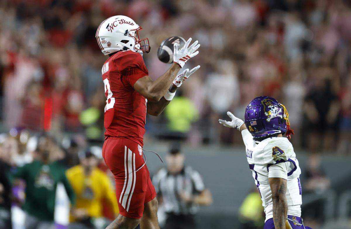 N.C. State wide receiver Teddy Hoffmann (12) pulls in a 50-yard reception over East Carolina wide receiver Johnny Williams (17) during the second half of N.C. State’s 24-17 victory over ECU at Carter-Finley Stadium in Raleigh, N.C., Thursday, August 28, 2025.