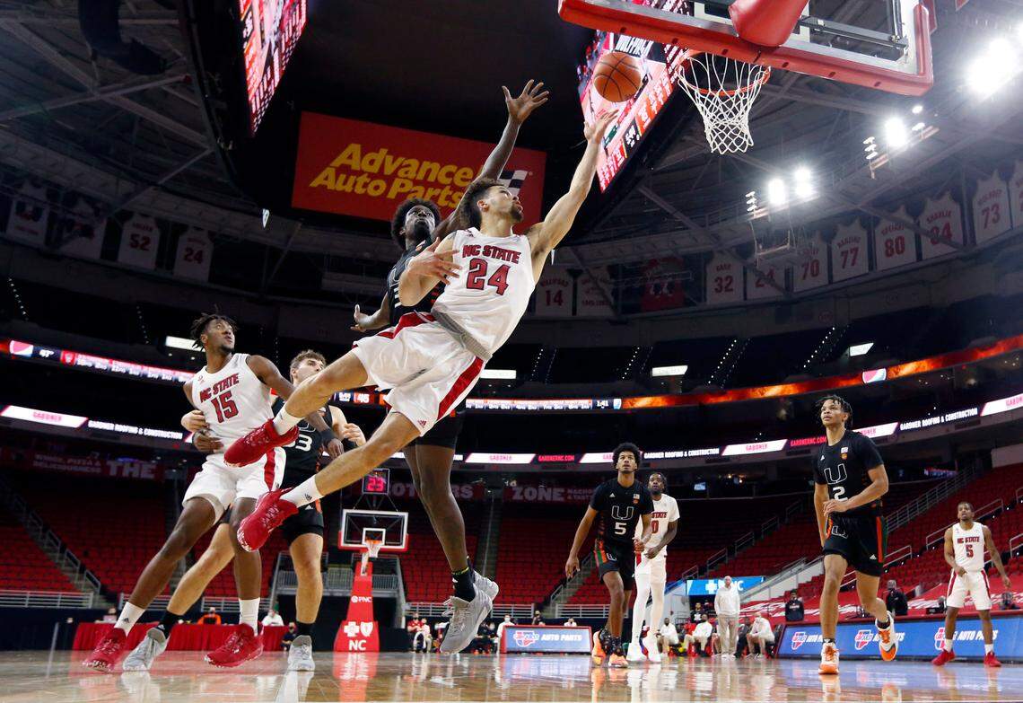 N.C. State’s Devon Daniels (24) shoots as Miami’s Nysier Brooks (3) defends during Miami’s 64-59 victory over N.C. State at PNC Arena in Raleigh, N.C., Saturday, January 9, 2021.