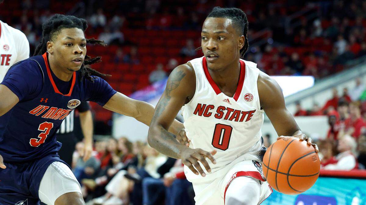 N.C. State’s DJ Horne (0) drives around UT Martin’s Jordan Sears (3) during the first half of N.C. State’s game against UT Martin at PNC Arena in Raleigh, N.C., Tuesday, Dec. 12, 2023.