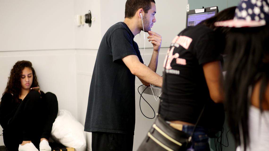 Nick Gonzalez, center, and Iris Hernandez, far left, use the Express Library Fayetteville Street in Raleigh on Oct. 19, 2016. Gonzalez said he came to the library daily to use the internet because his only access is his smartphone.