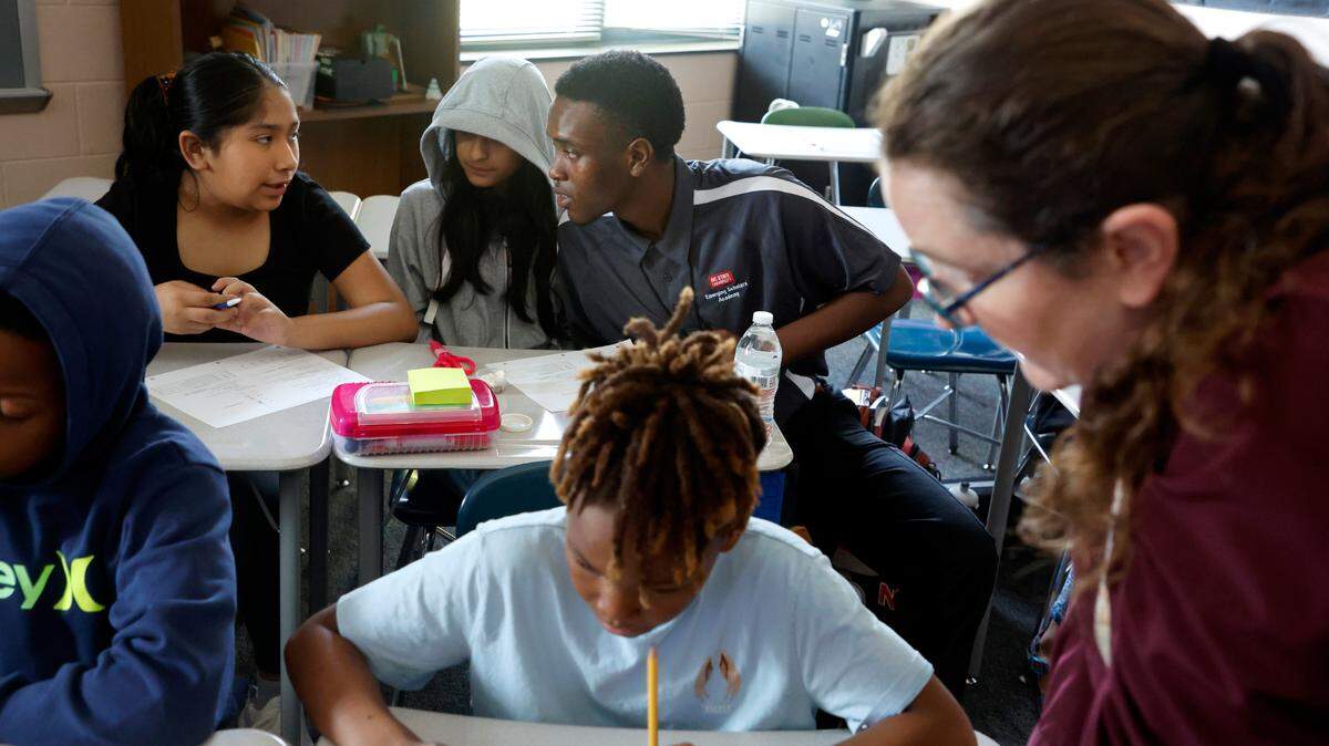 Jahzar Fields works with Perla Ramirez Urieta, left, and Alandra Gonzalez Alvarez while student teaching in Kerry Miquel’s 6th grade social studies class at Dillard Drive Magnet Middle School in Raleigh, N.C., Wednesday, Sept. 6, 2023.