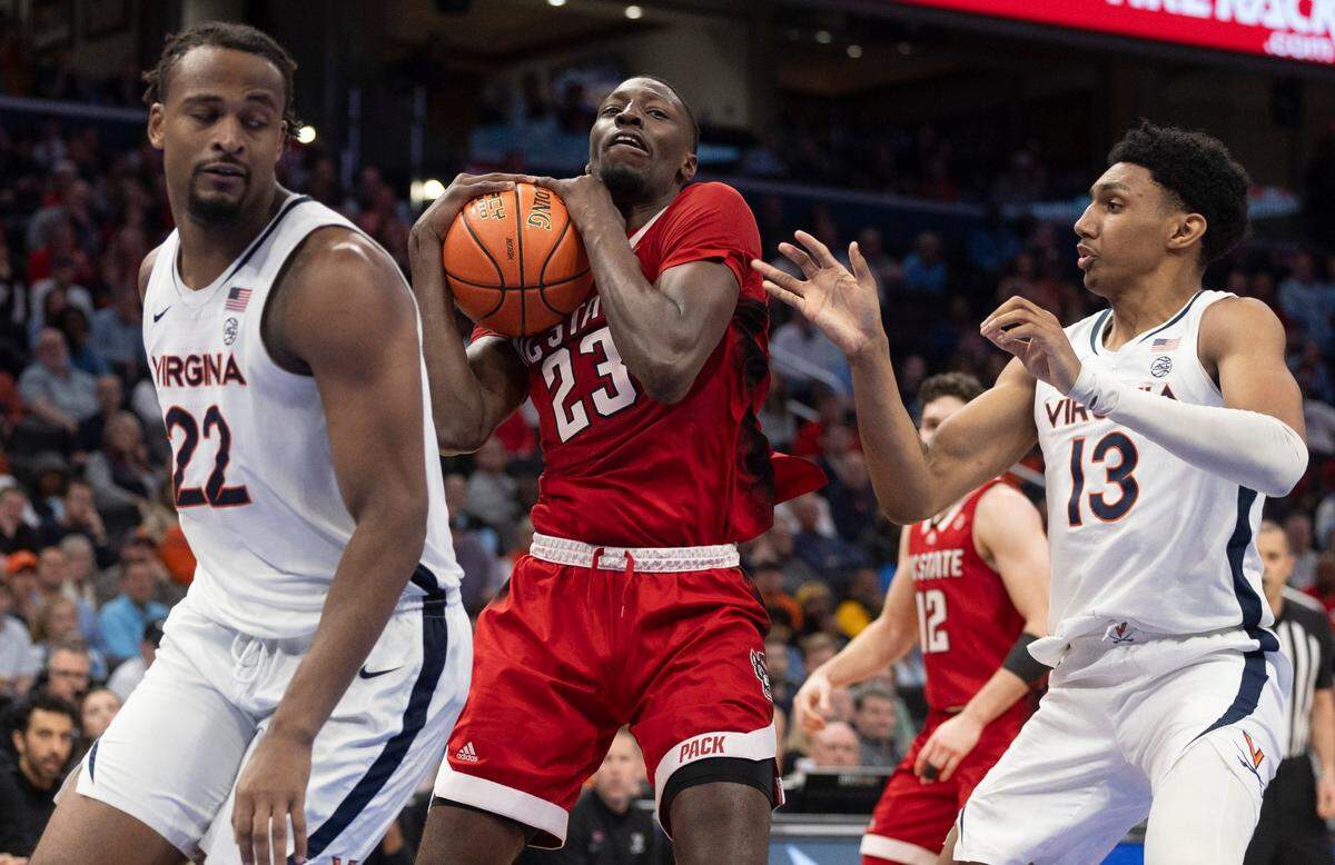 N.C. State’s Mohamed Diarra (23) grabs one of his game high 12 rebounds between Virginia’s Jordan Minor (22) and Ryan Dunn (13) in the second half during the semi-finals of the ACC Men’s Basketball Tournament at Capitol One Arena on Friday, March 15, 2024 in Washington, D.C.