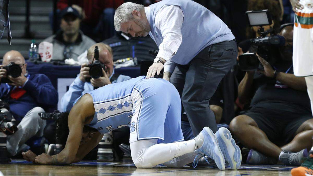 North Carolina trainer Doug Halverson checks on Joel Berry II (2) during the second half of UNC's 82-65 victory over Miami.
