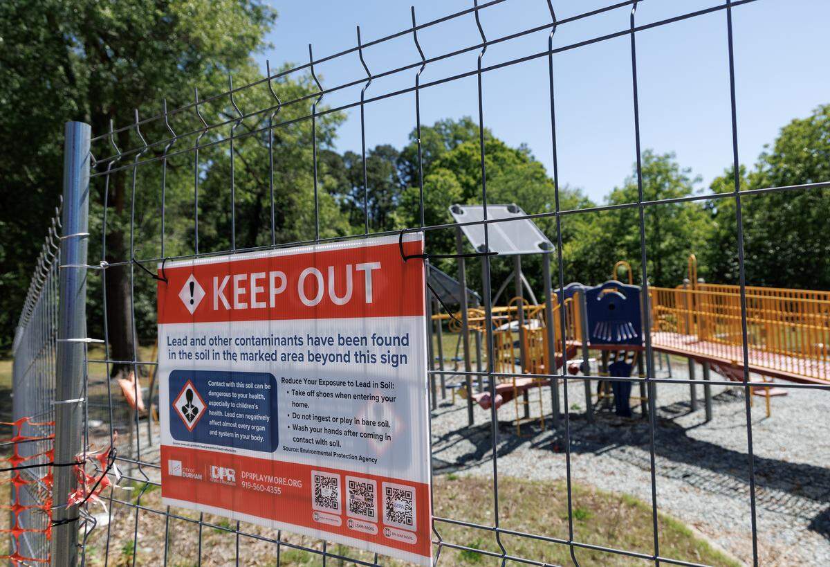 Fencing surrounds a playground area at East Durham Park on Friday, May 8, 2026. The park is one of five in Durham that remain closed after the sites were found to have high levels of lead in the soil. 