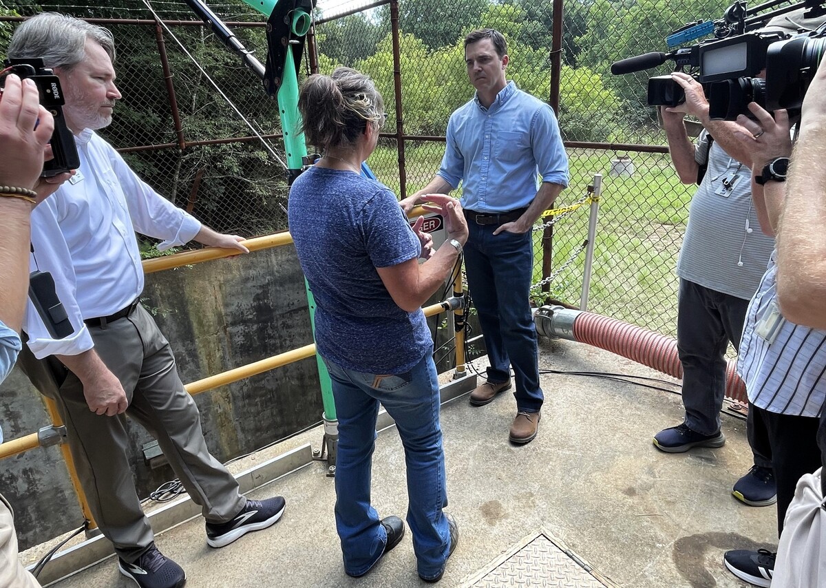 Attorney General Jeff Jackson listens as Hillsborough Utilities Director Marie Strandwitz explains how the raw sewage well and River Pump Station flooded after Tropical Depression Chantal dropped over 8 inches of rain in just a few hours July 6, 2025.
