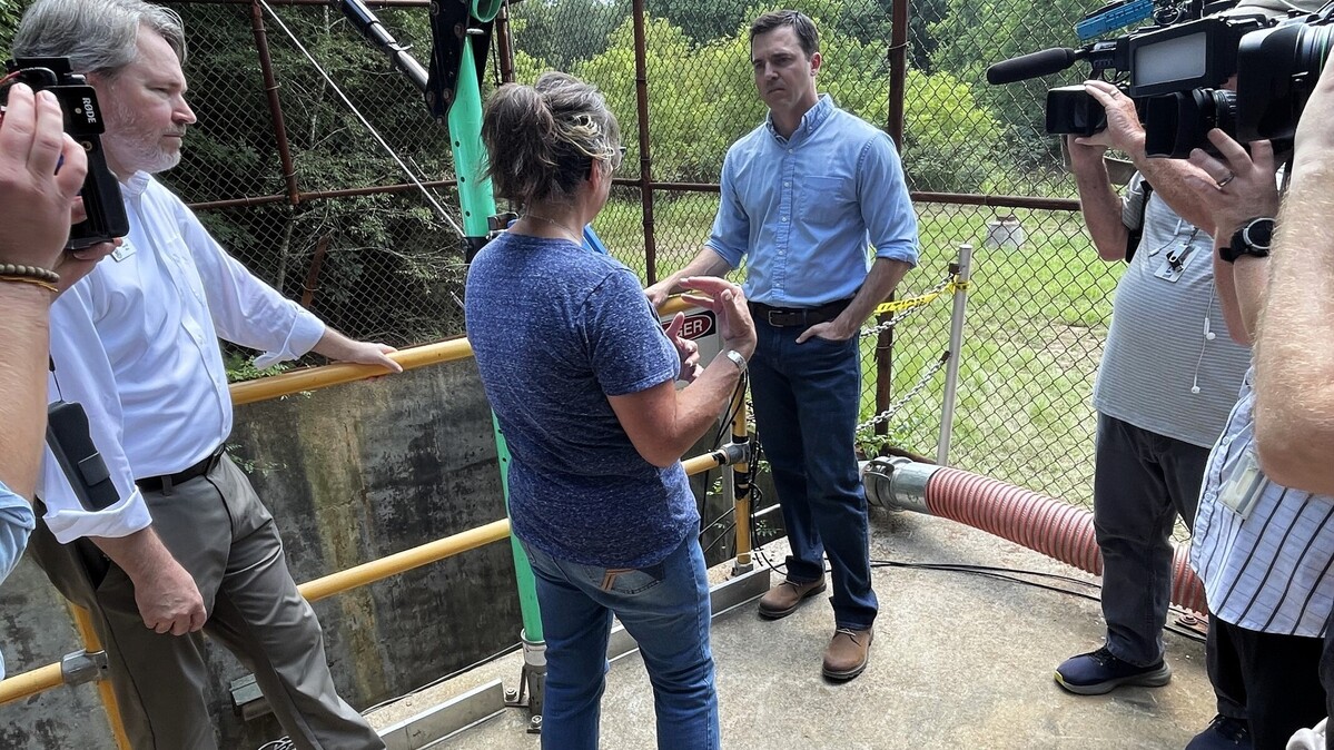 Attorney General Jeff Jackson listens as Hillsborough Utilities Director Marie Strandwitz explains how the raw sewage well and River Pump Station flooded after Tropical Depression Chantal dropped over 8 inches of rain in just a few hours July 6, 2025.