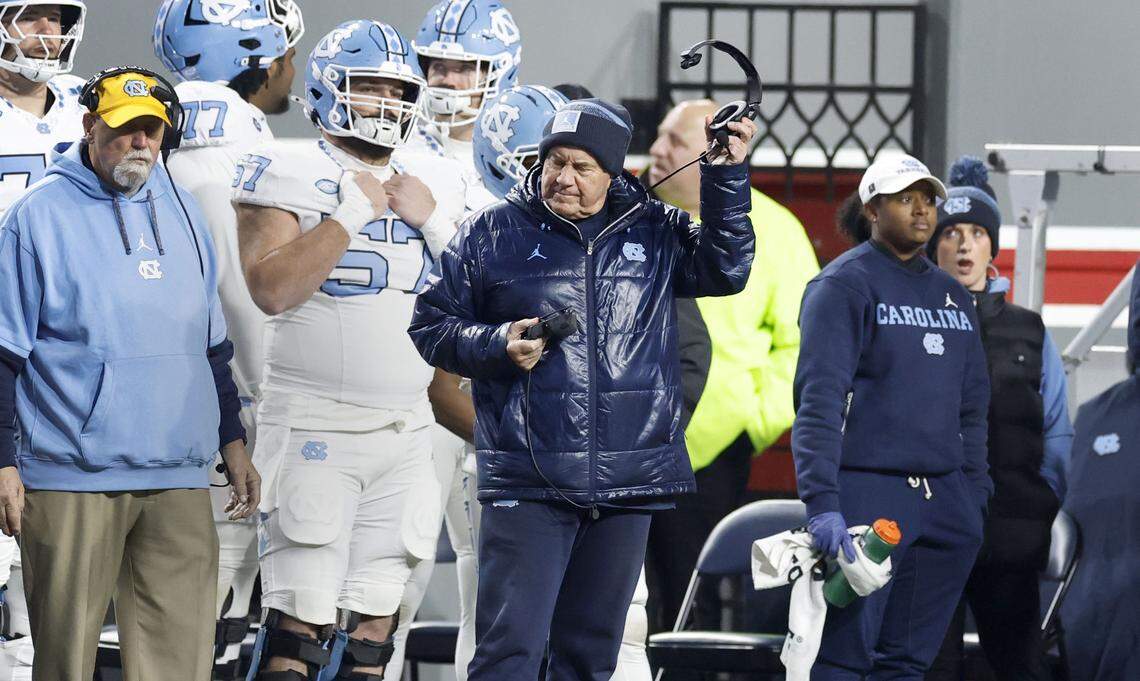 North Carolina head coach Bill Belichick takes off his headphones near the end of the first half of N.C. State’s game against UNC at Carter-Finley Stadium in Raleigh, N.C., Saturday, Nov. 29, 2025.