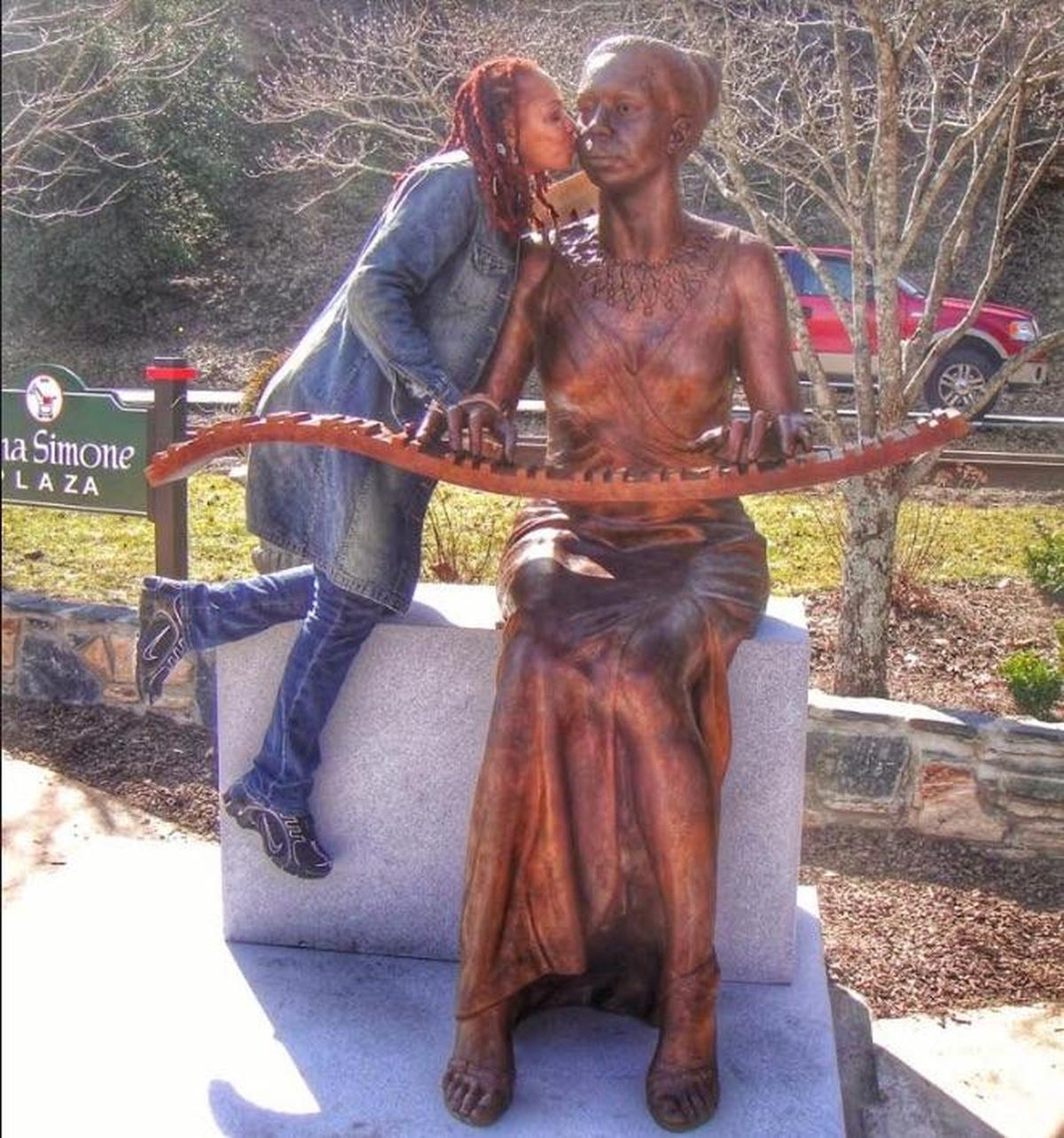 Lisa Kelly, daughter of Nina Simone, kisses the statue of her mother at its dedication in 2010.