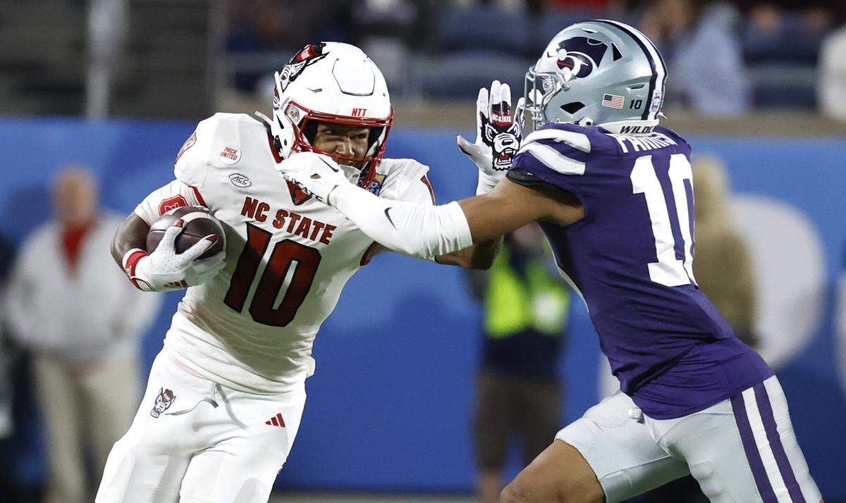 N.C. State wide receiver KC Concepcion (10) stiff-arms Kansas State cornerback Jacob Parrish (10) during the first half of N.C. State’s game against Kansas State in the Pop-Tarts Bowl at Camping World Stadium in Orlando, Fla., Thursday, Dec. 28, 2023.