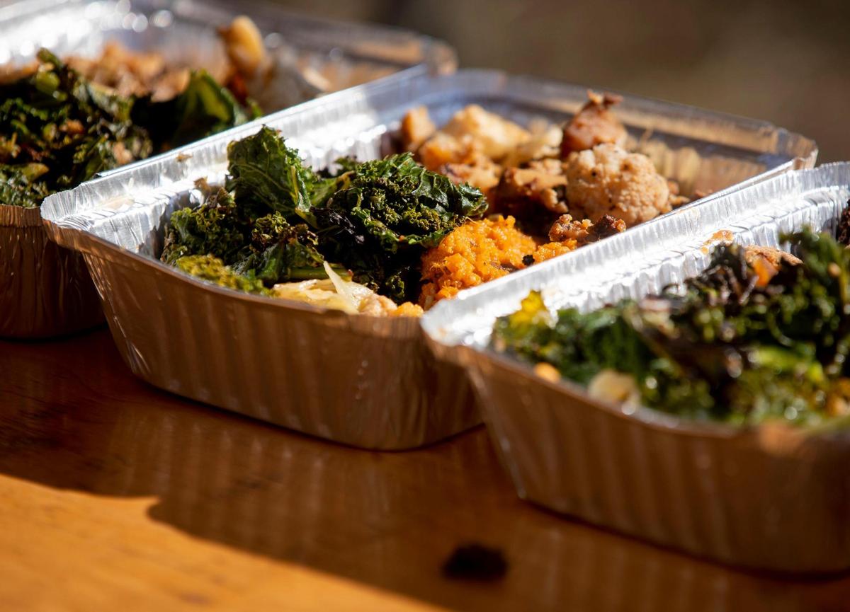 Aluminum trays filled with chicken and vegetables await final assembly on the final day of the five-day no-contact cookout known as Feed Durham that began as a response to the increase of food insecurity at the start of coronavirus pandemic, bringing dozens of volunteers together every six to eight weeks to cook well-seasoned and nutrient-dense meals for people in need, on Wednesday, Mar. 3, 2021, in Durham, N.C.
