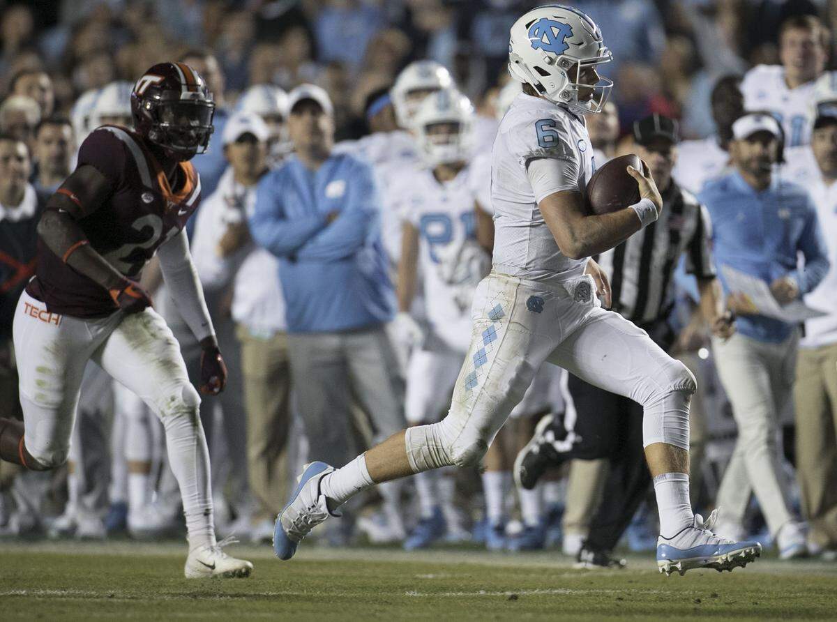 North Carolina quarterback Cade Fortin (6) rushes for 40 yards in the first quarter ahead of Virginia Tech’s Reggie Floyd (21) on Saturday, October 13, 2018 at Kenan Stadium in Chapel Hill, N.C.