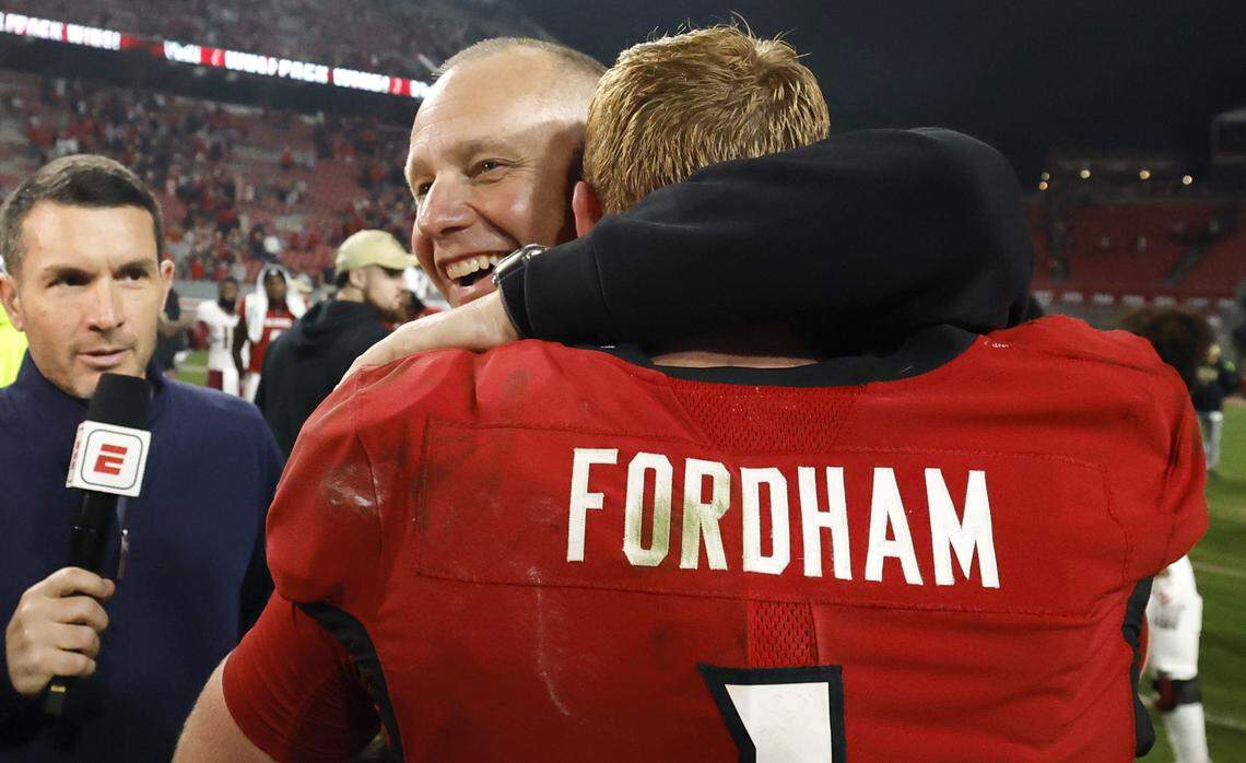 N.C. State head coach Dave Doeren hugs Caden Fordham (1) after N.C. State’s 21-11 victory over Florida State at Carter-Finley Stadium in Raleigh, North Carolina, on Nov. 21, 2025.