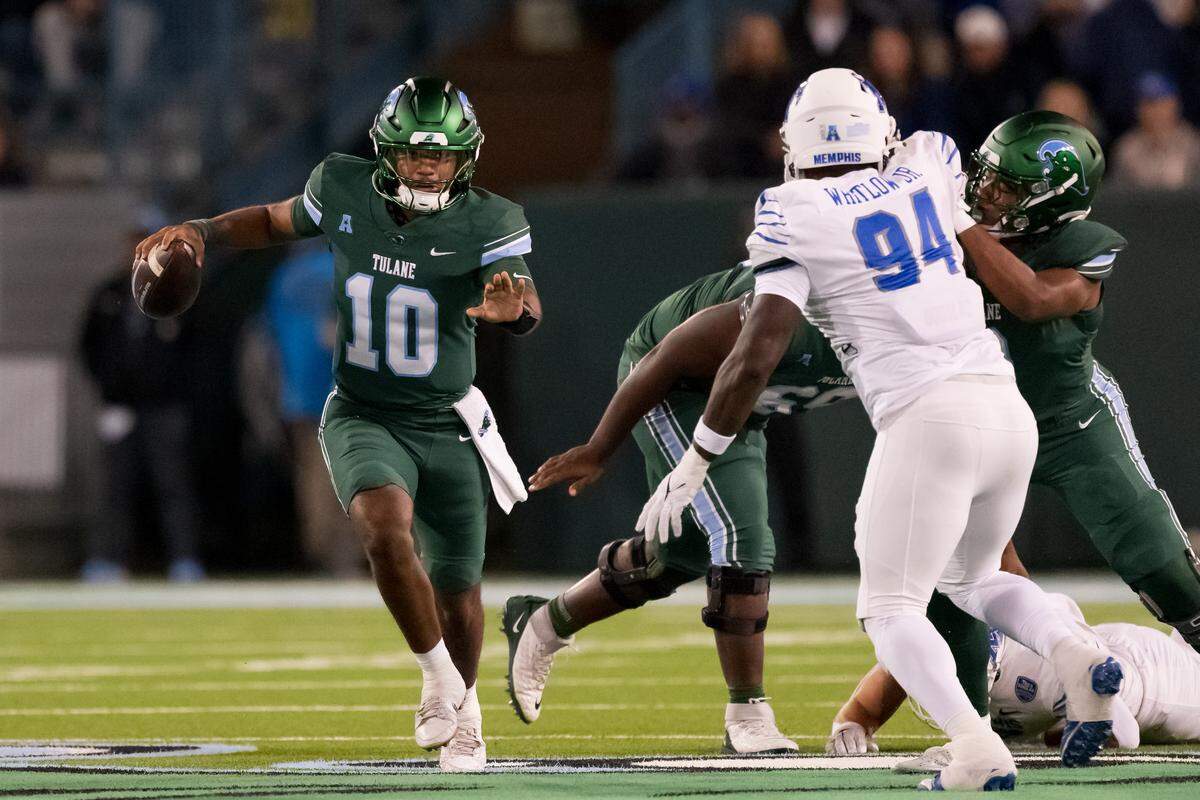 Tulane Green Wave quarterback Darian Mensah (10) runs against Memphis Tigers defensive lineman William Whitlow Jr. (94) during the first quarter at Yulman Stadium. 